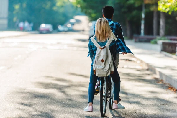 Back view of students riding bicycle together on street — Stock Photo