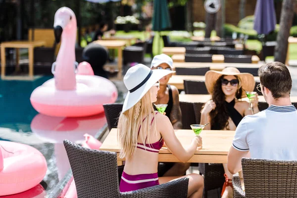 Amici passare del tempo insieme e bere cocktail in piscina — Foto stock