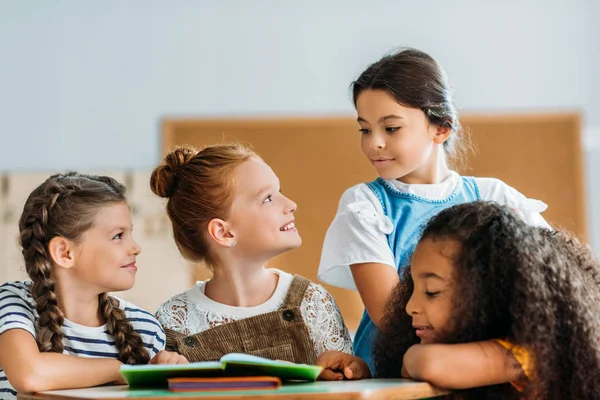 Schülerinnen unterhalten sich in der Pause im Klassenzimmer mit ihrer Klassenkameradin — Stockfoto