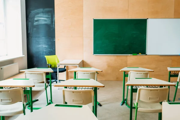 Interior of empty modern classroom with blank chalkboard at school — Stock Photo