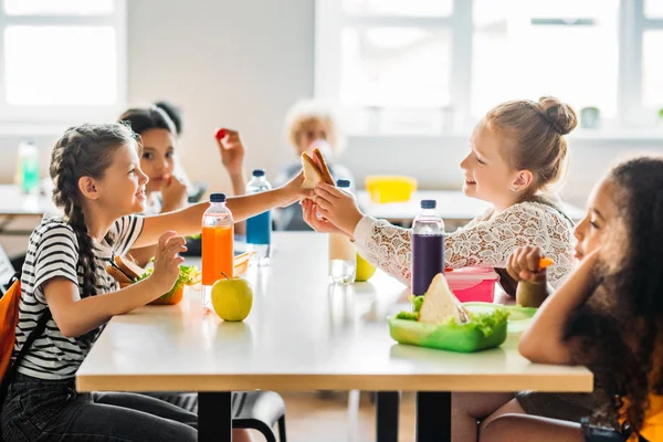 Adorable schoolgirls taking lunch at school cafeteria — Stock Photo