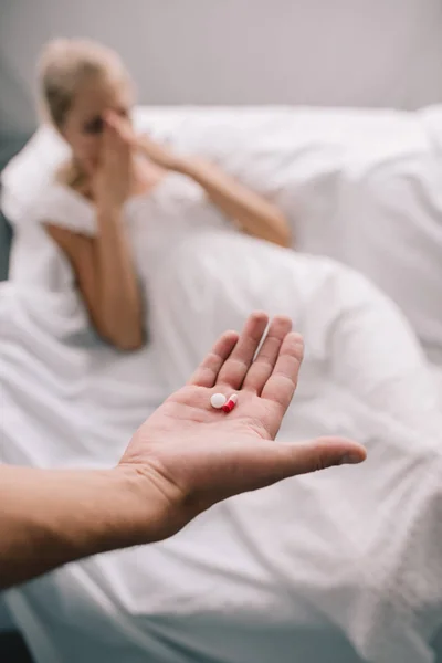 Schnappschuss von Mann mit Tabletten in der Hand und schwangerer Frau, die sich zu Hause unwohl fühlt — Stockfoto