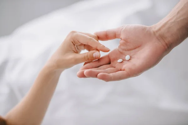 Visão parcial do homem dando medicamentos para a mulher em casa — Fotografia de Stock