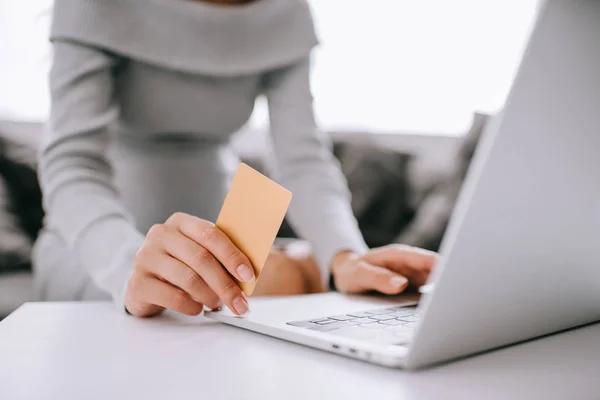 Plan recadré de femme enceinte avec carte de crédit et ordinateur portable acheter des biens en ligne à la maison — Photo de stock