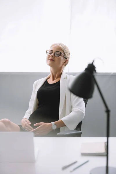 Porträt einer schwangeren Geschäftsfrau mit Brille am Arbeitsplatz im Büro — Stockfoto
