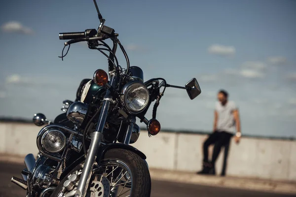 Selektive Fokussierung von klassischem Chopper-Motorrad und Mann im Hintergrund — Stockfoto
