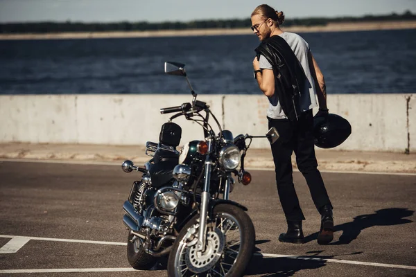 Jovem motociclista com helicóptero motocicleta na cidade com rio — Fotografia de Stock