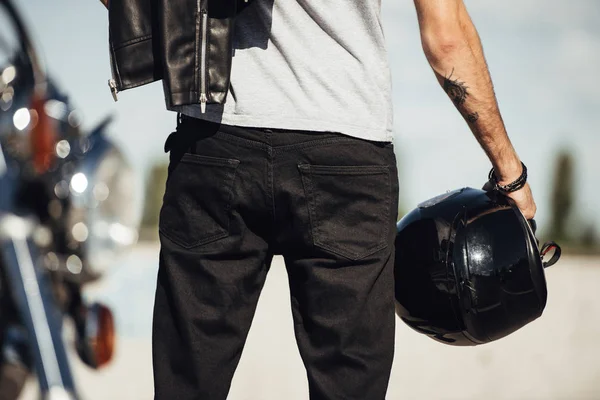 Midsection view of male biker holding motorbike helmet — Stock Photo