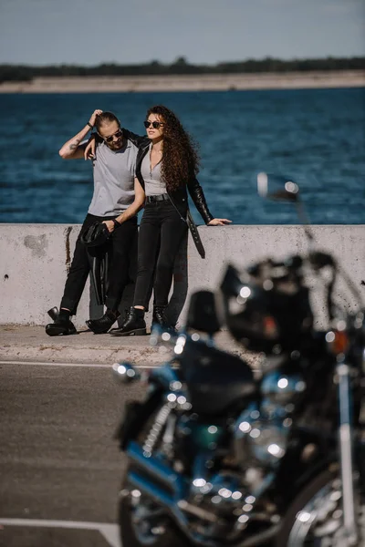 Selective focus of young couple with motorcycle on foreground — Stock Photo
