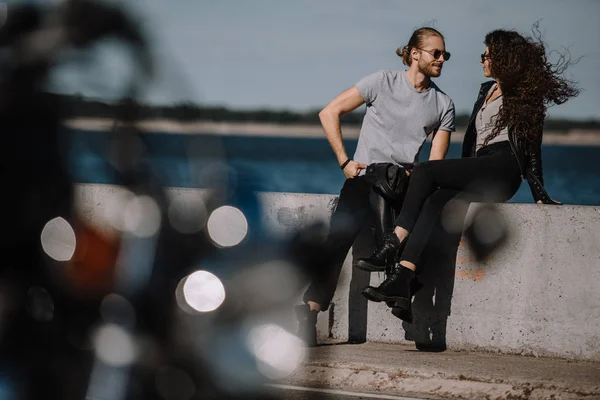 Junges Paar am Kai mit Motorrad im Vordergrund — Stockfoto