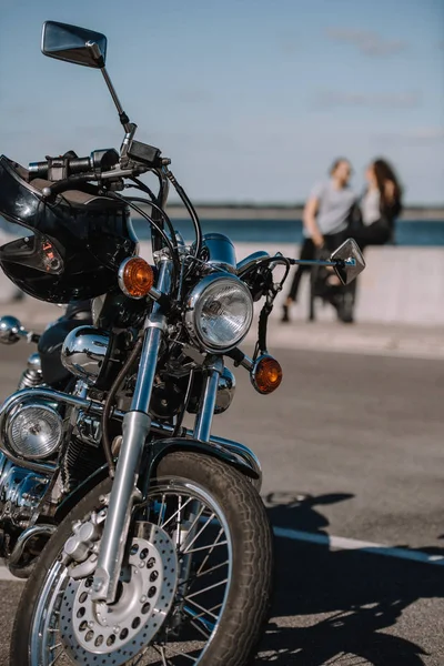 Foco seletivo da motocicleta clássica helicóptero com casal em segundo plano — Fotografia de Stock