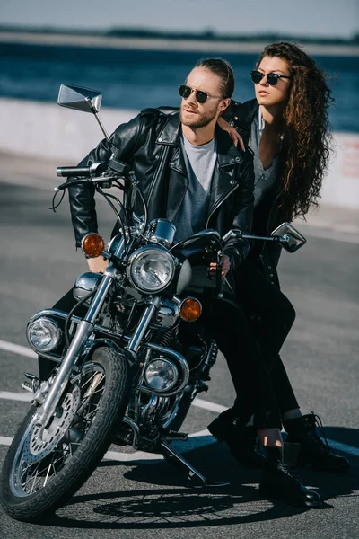 Couple of bikers in black leather jackets sitting on classic motorcycle — Stock Photo