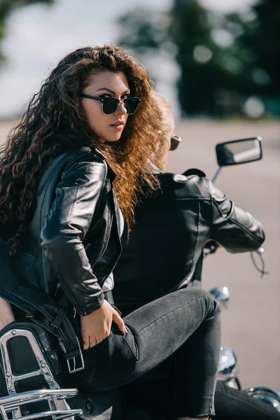 Par de motociclistas em jaquetas de couro preto sentado na motocicleta — Fotografia de Stock