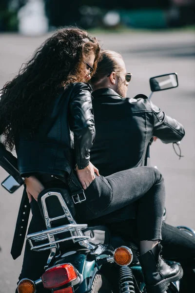 Vista trasera de un par de ciclistas en chaquetas de cuero negro sentados en motocicleta - foto de stock