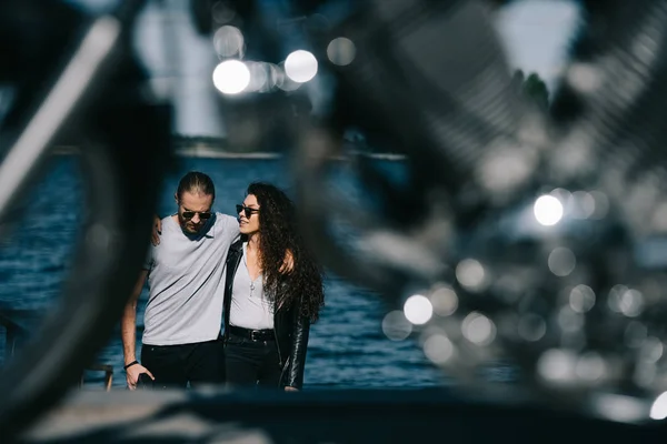 Paar umarmt sich und geht zum Motorrad im Vordergrund, selektiver Fokus — Stockfoto