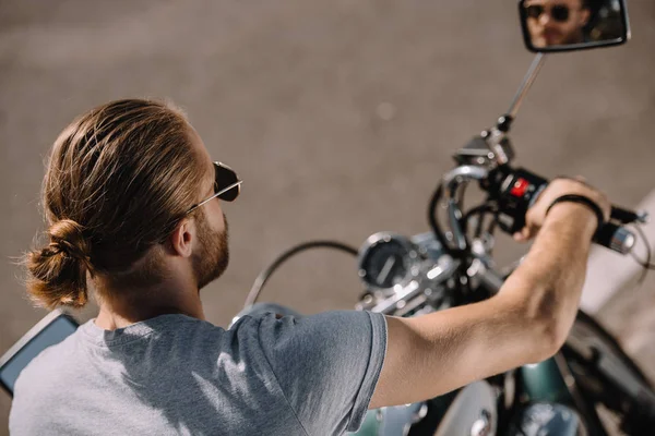 Молодой человек сидит на винтажном классическом мотоцикле — стоковое фото