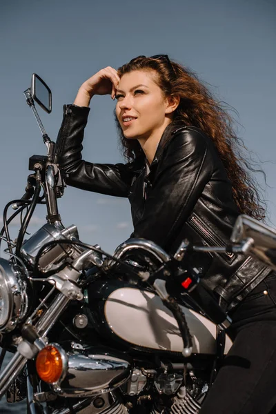 Attractive female biker sitting on vintage classical motorbike — Stock Photo