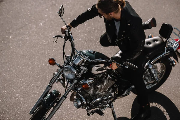 Biker sitting on vintage chopper motorcycle on asphalt road — Stock Photo