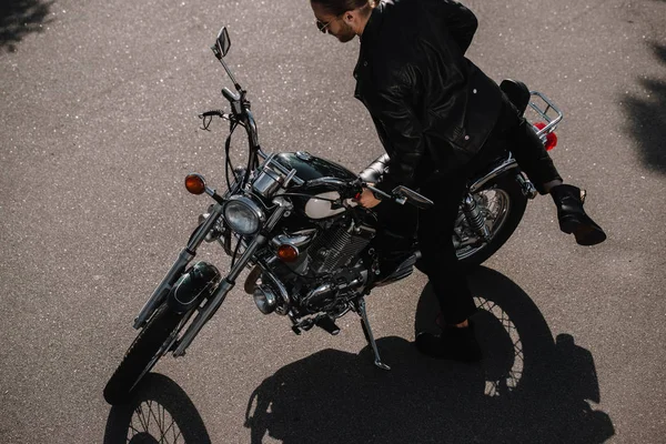 Young biker sitting on vintage classical motorcycle on road — Stock Photo