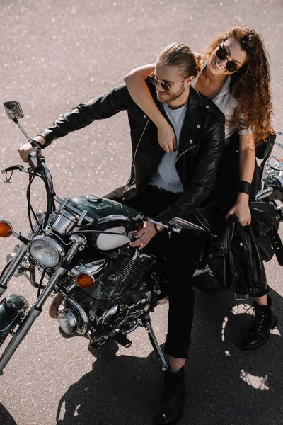 Young couple of bikers sitting on classical cruiser motorcycle on asphalt road — Stock Photo