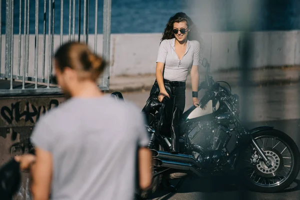 Selective focus of biker going to girlfriend with vintage motorbike — Stock Photo