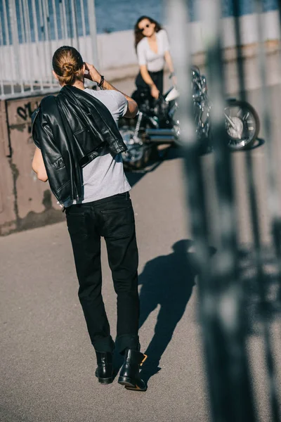 Selective focus of biker going to girlfriend with classical chopper motorbike — Stock Photo