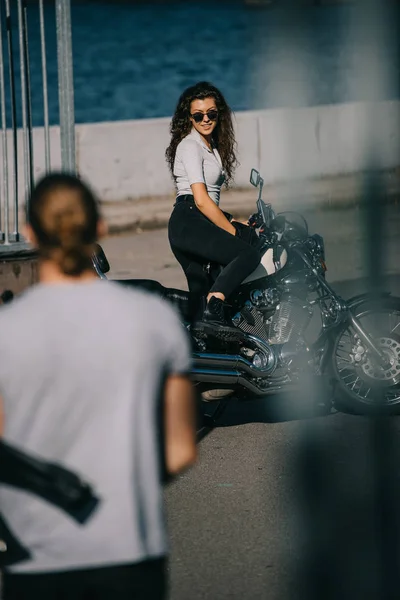 Foco seletivo do homem indo para a menina com motocicleta clássica — Fotografia de Stock