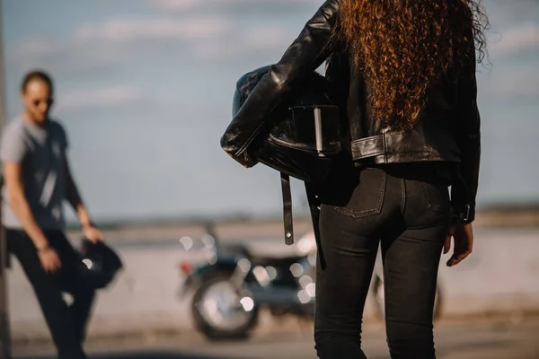 Visão traseira da namorada segurando capacete e indo para namorado com motocicleta clássica — Fotografia de Stock