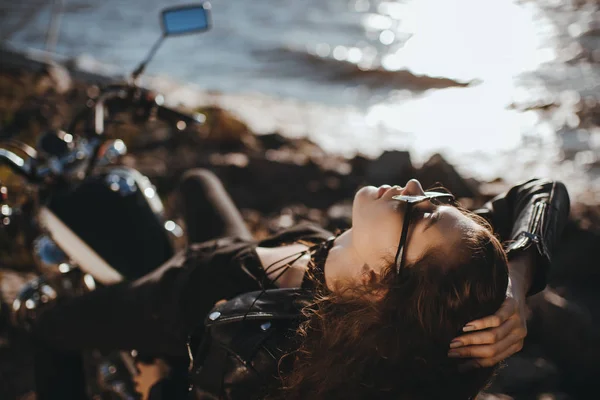 Belle fille en lunettes de soleil couché sur la moto classique — Photo de stock