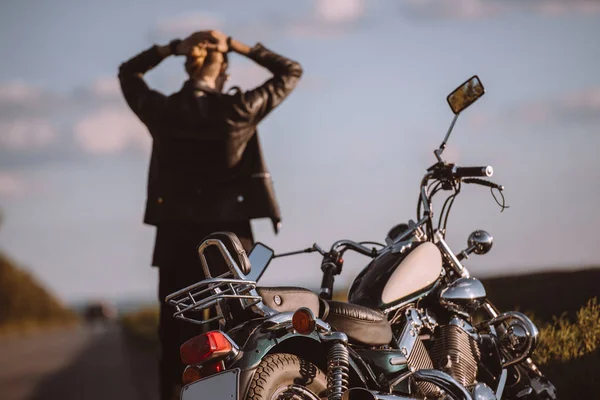 Back view of confused biker with broken motorcycle on road, selective focus — Stock Photo