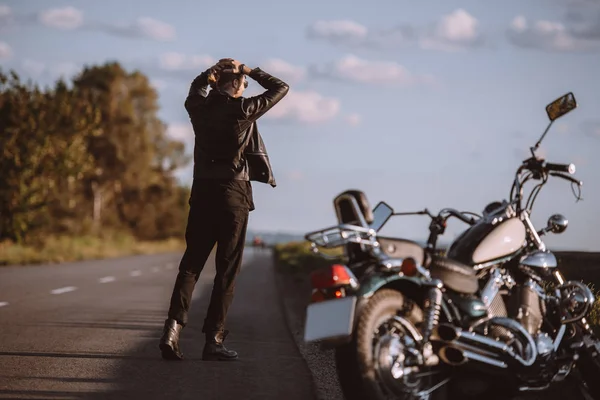 Frustrated man on road with broken cruiser motorcycle, selective focus — Stock Photo