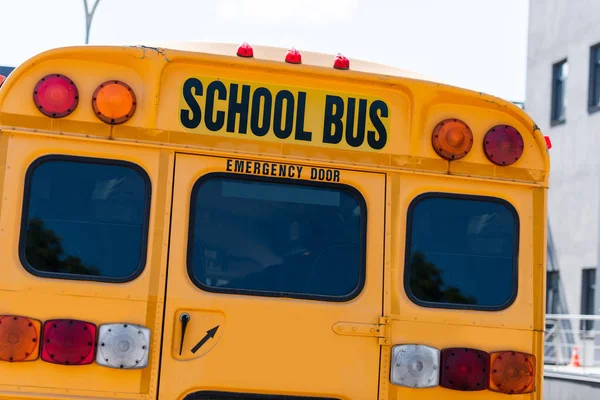 Rear view of traditional school bus with inscription over back door — Stock Photo