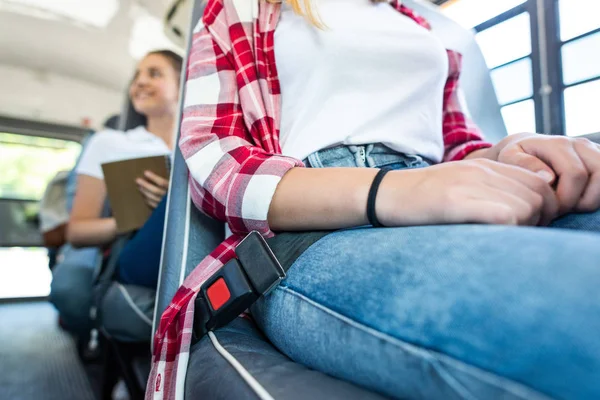 Обрезанный снимок школьницы, сидящей в школьном автобусе с ремнем безопасности — стоковое фото