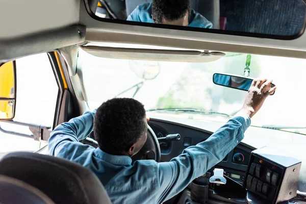 Piloto americano africano maduro ajustando espelho retrovisor no ônibus — Fotografia de Stock