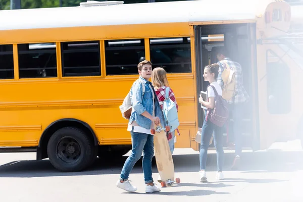 Gruppo di studiosi adolescenti che camminano all'interno dello scuolabus — Foto stock