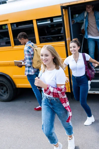 Actif heureux adolescent chercheurs courir dehors école bus — Photo de stock