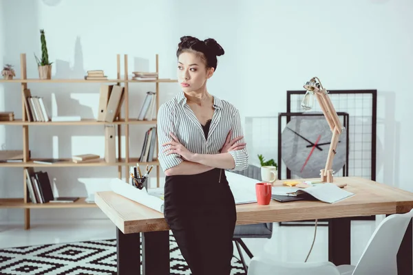 Confident asian businesswoman standing with crossed arms and looking away — Stock Photo