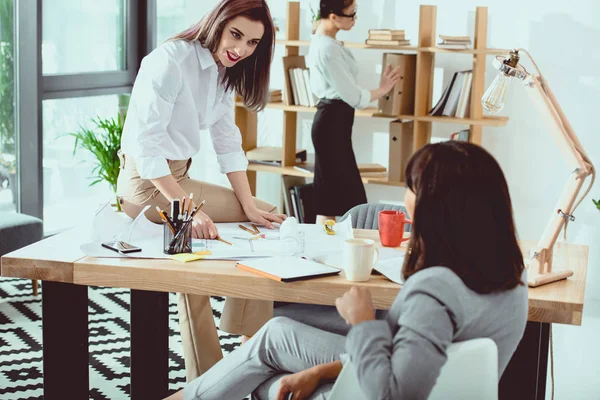 Jeunes femmes d'affaires professionnelles travaillant ensemble dans un bureau moderne et discutant — Photo de stock