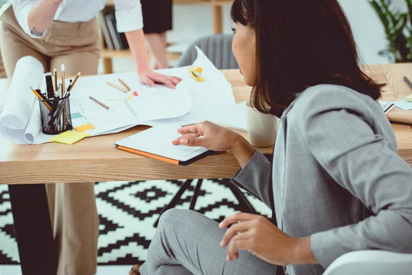 Joven mujer de negocios afroamericana sentada a la mesa y usando tableta digital con pantalla en blanco - foto de stock