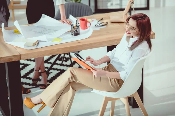 Junge kaukasische Designerin arbeitet im Büro mit digitalem Tablet — Stockfoto