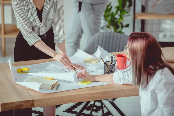 Plan recadré de designers en tenue formelle travaillant avec des plans au bureau — Photo de stock