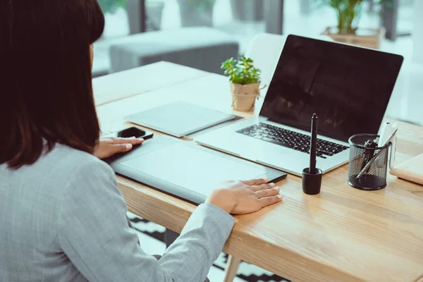 Schnappschuss eines Designers, der im Büro mit Tablet und Laptop arbeitet — Stockfoto