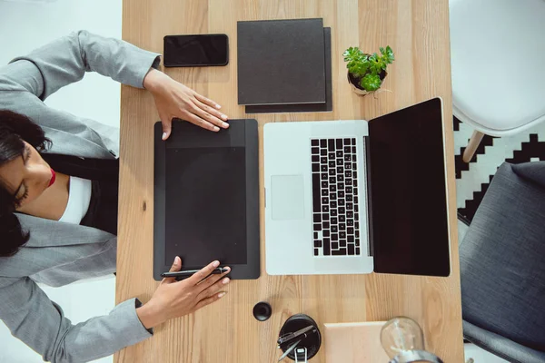 Overhead view of young designer drawing on graphics tablet at workplace — Stock Photo