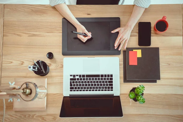 Cropped shot of woman working with drawing tablet and laptop on tabletop — Stock Photo