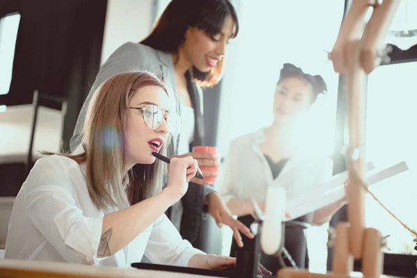 Молодые мультиэтнические дизайнеры, работающие вместе в офисных помещениях — стоковое фото