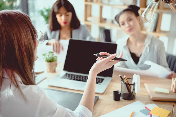 Young multiethnic architects with digital devices and blueprints working at office — Stock Photo