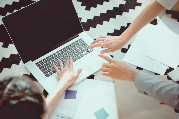 Cropped shot of young women working on laptop with blank screen — Stock Photo