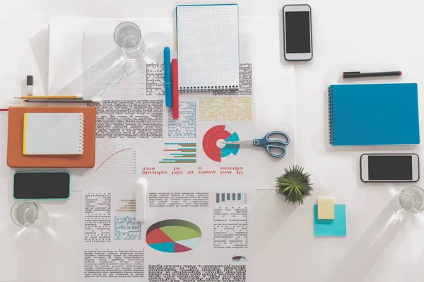 Top view of smartphones with blank screens, papers and office supplies at workplace — Stock Photo