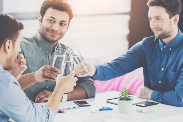 Jovens empresários sorridentes bebendo água e discutindo novo projeto, conceito de trabalho em equipe de negócios — Fotografia de Stock