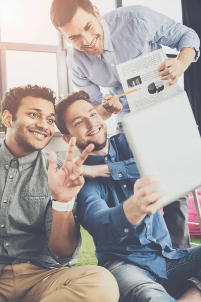 Souriant jeunes hommes d'affaires utilisant une tablette numérique et montrant des graphiques, concept de travail d'équipe d'affaires — Photo de stock